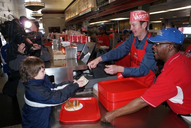 NASCAR's Kurt Busch (second from right) put on a hat and apron to sell food at The Varsity, a famous eatery in Atlanta that sells more than 10,000 hot dogs a day. It was part of NASCAR's Winner's Circle Program, which promotes upcoming races.