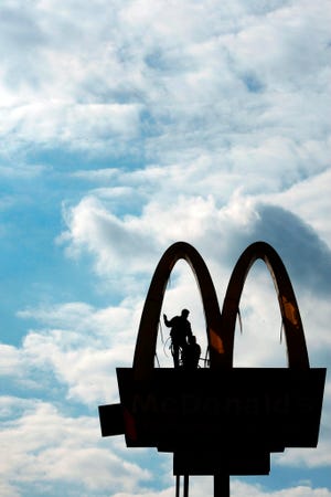 Randy Peters, co-owner of AAA Sign Company, Inc., based in Augusta, is seen silhouetted in one of the arches Randy Peters, co-owner of AAA Sign Company, Inc., based in Augusta, is seen silhouetted in one of the McDonald's arches at Columbia and South Belair roads in Evans. Below is his co-worker Ronald Scheiber of North Augusta. The two have been in the sign business for 35 years and 15 years respectively. They were replacing bulbs and troubleshooting.