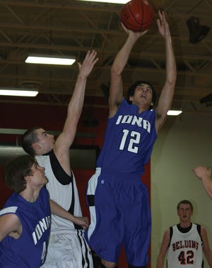 Ionia senior Justin VanSyckle takes a shot over Belding senior Chris Daller Tuesday night in the Bulldogs’ game against the Redskins.