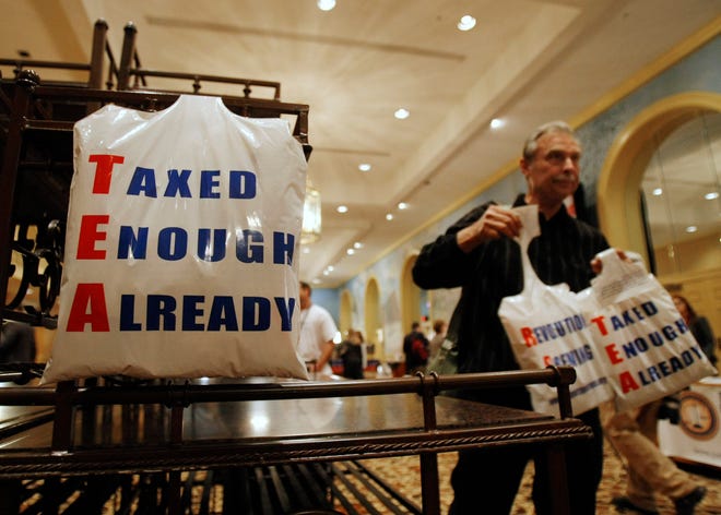 Bill Bruss of Winfield, Ill., gives away plastic bags in the vendor area at the National Tea Party convention in Nashville on Feb. 5. The national Tea Party movement is growing amid dissatisfaction with government and taxation, with several groups opening in the South Shore area.