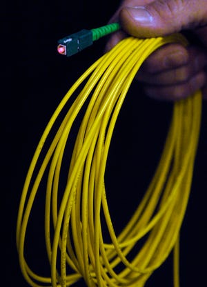 A single strand of coated optical fiber cable is lighted using a fault locator. Optical fiber is a wirelike thread of transparent glass that is used to transmit light signals and images.