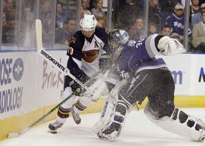 Atlanta Thrashers' Colby Armstrong (20) and Tampa Bay Lightning goaltender Antero Nittymaki (30) collide behind the goal chasing a loose puck during the first period Saturday in Tampa.