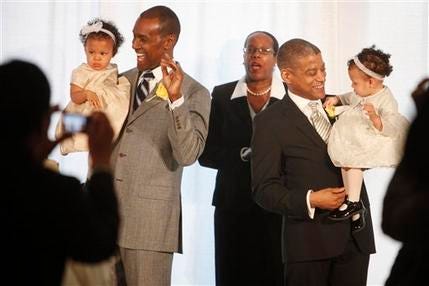 Rocky Galloway, left, and Reginald Stanley hold their twin daughters after they were married by Rev. Sylvia E. Sumter, center, Tuesday, March 9, 2010, the first day that gay marriage was legal in Washington.