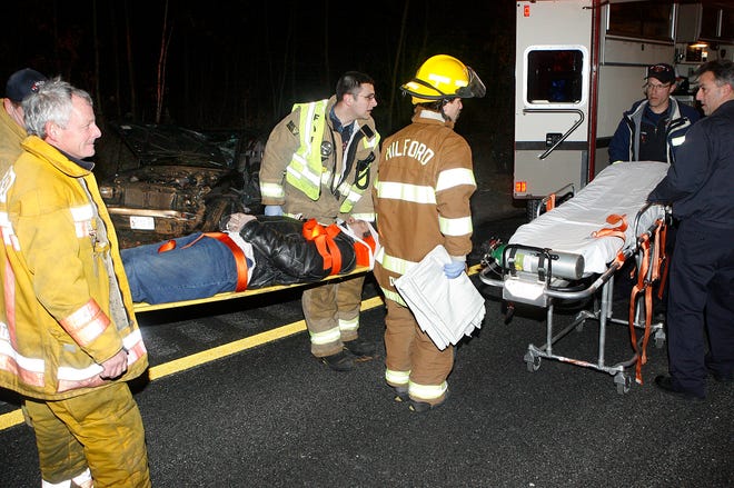 A victim is brought to a Hopkinton ambulance after a rollover involving a Toyota Tacoma, Tuesday night around 10:45 p.m. on Interstate 495 in Milford.