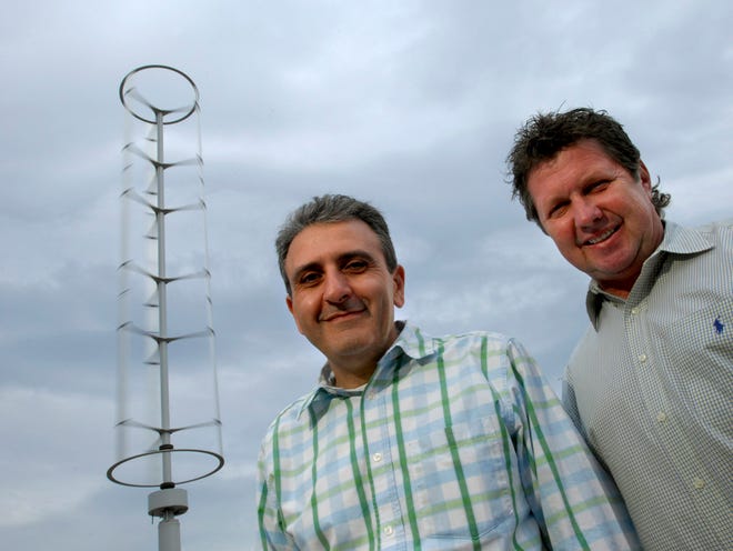 WILL DICKEY/The Times-UnionSafa M. Mansouri (left), property manager of Discovery Plaza at Atlantic Boulevard and St. Johns Bluff Road, and Frank Erickson, president of Erickson Energy, stand near one of the two 30-foot-tall spinning wind spires.