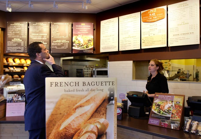 A customer reviews the sandwich board at the Panera store in Brookline. Panera bread company is posting calories on its menus nationally.