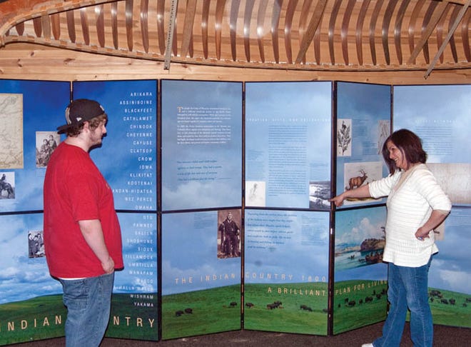 Travis Teeple (left) and Bay Mills Community College Librarian Patty Teeple preview the “Lewis and Clark and the Indian Country” exhibit at the Bay Mills Public Library and Cultural Learning Center on Wednesday. This exhibit is a set of six panel display units which tells the saga of the Corps of Discovery as it traveled west to explore the American west all the way to the Pacific Ocean and back. The display is open to the public from 8 a.m. to 8 p.m., Monday through Thursday, until April 23.