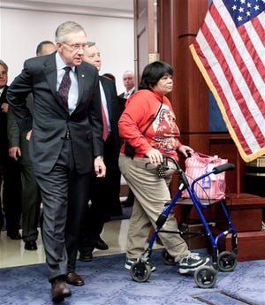 Senate Majority Leader Harry Reid of Nev., left, along with Gina Owens from Seattle, Wash.,left, whose daughter, Tiffany Owens died after losing her job and health care, Senate Majority Whip Richard Durbin of Ill. center, and others, arrive for a health care news conference on Capitol Hill in Washington, Thursday, March 11, 2010.