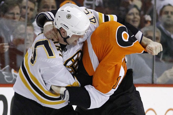 The Bruins' Mark Stuart, left, pulls the jersey over the Flyers' Ian Laperriere during a fight in the second period of Thursday's game in Philadelphia.