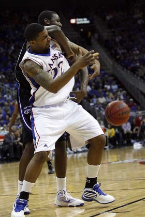 Kansas forward Marcus Morris (22) and Kansas State forward Curtis Kelly tangle for a rebound in the first half. Morris won the battle and KU won the war with a 72-64 victory over the Wildcats in Saturday's championship game of the Big 12 Tournament in Kansas City.