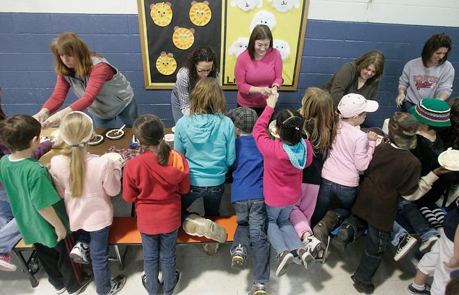 Kids line up to get their bowl of icecream at Berkley Community School for raising more than $3,000 for Haiti.