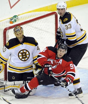 Boston Bruins' Zdeno Chara, right, checks New Jersey Devils' Zach Parise in front of Bruins goaltender Tuukka Rask during the second period of Monday's game in Newark, N.J.