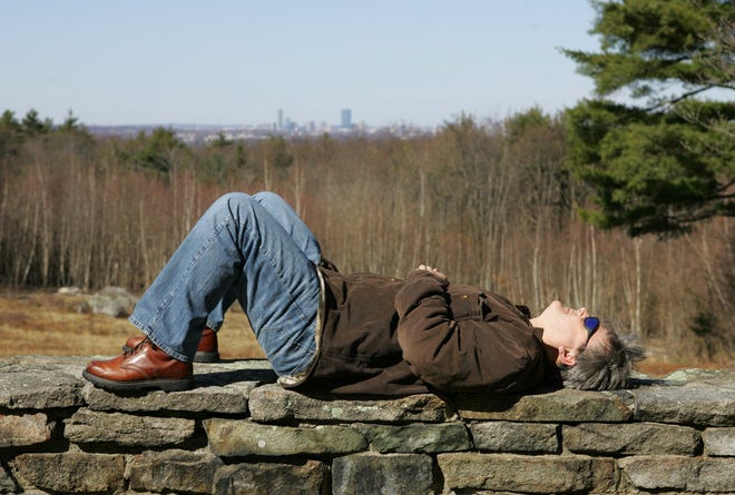 A man who declined to give his name soaks up the sunshine at the overlook along Chickatawbut Road in the Blue Hills Reservation in Quincy on Wednesday, when the temperature climbed into the 60s.