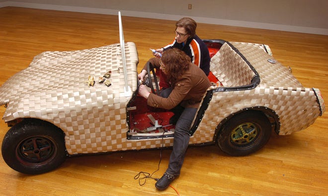 Hingham artists Jeanne Wiley, left, and Ann Conte created “The Woven Car” from an MG convertible. It is part of an exhibit at the South Shore Art Center in Cohasset.