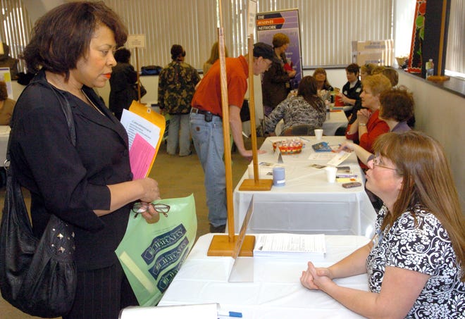 Elaine Randle of Canton talks with Janeen Lutz of Alfred Nickles Bakery at the job fair held Thursday at the Stark County District Library in Canton.