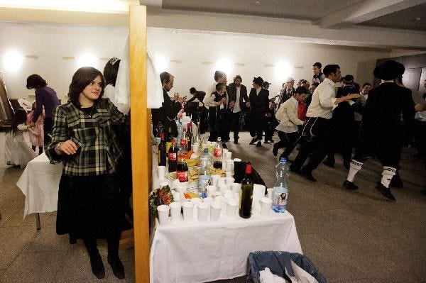 A Feb. 24, 2010 photo shows an orthodox Jewish woman looking from behind a separation barrier at men dancing, to celebrate the holiday of Purim at the Lauder Yeshurun community in Berlin. The Jewish holiday of Purim celebrates the Jews' salvation from genocide in ancient Persia, as recounted in the Scroll of Esther.