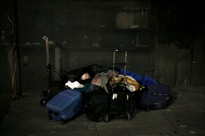 A woman sleeps on the street in Manhattan. The Bloomberg administration 
said Friday the number of people living on the streets soared in the past 
year.NEW YORK TIMES / DAMON WINTER