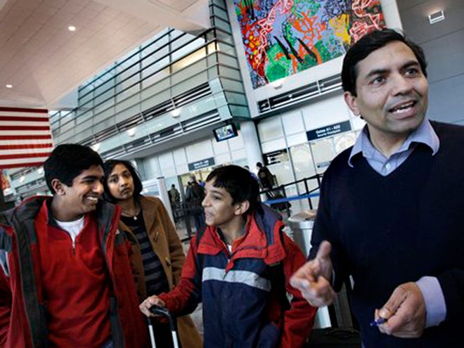 In this March 8, 2010 photo, Sanjeev Verma, right, of Lincoln, Mass. speaks about the new security measures at Logan International Airport in Boston before heading to Salt Lake City with his wife, Girija, and their two sons, Gaurav, 14, and Kunaal, 10.