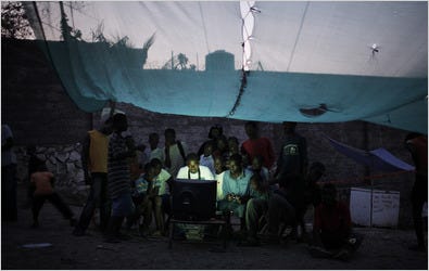 Haitians set up a video game station running off a generator under a tent in the refugee camp at the Pétionville Club, once an enclave for Haiti’s elite.