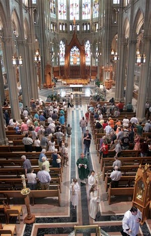 In this June 5, 2005 file photo, a procession moves down the center isle at the Catherdal in Covington, Ky., during mass. The Roman Catholic Diocese of Covington agreed Friday to set up a $120 million fund to compensate victims of child-molesting priests and other employees. While the Roman Catholic church in Europe reels from a widening sex abuse crisis, the scandal that has plagued the U.S. church for nearly a decade is tapering off, a report released Tuesday March 23, 2010 says.