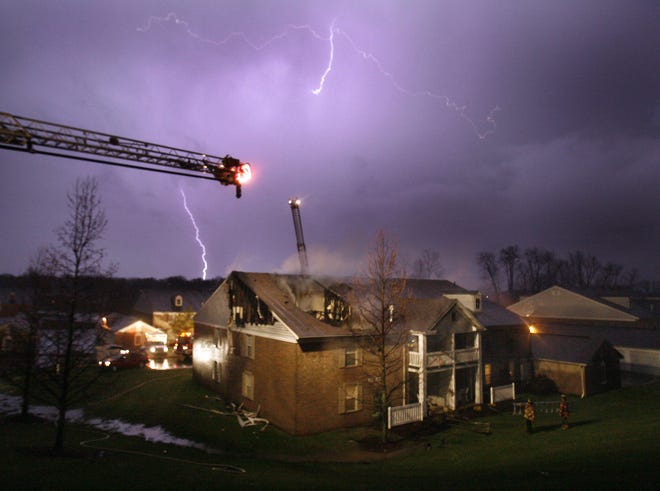 Lightning dances across the sky Monday night after fire burned a hole in the roof of Kings Creek apartments.