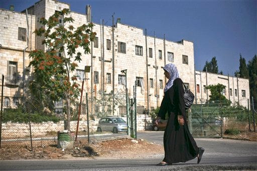 In this July 19, 2009 file photo, a Palestinian woman walks outside the Shepherd Hotel in East Jerusalem. The Jerusalem municipality has approved a new building plan for an east Jerusalem apartment complex that threatens to stir a new diplomatic crisis. The new project calls for tearing down the hotel and building 20 apartments plus a three-level underground parking lot instead. The Jerusalem municipality said Wednesday, March 24, 2010, that the final go ahead was given a week ago.