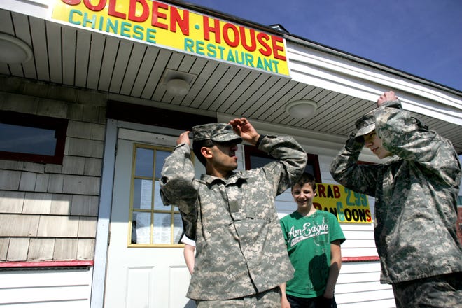 Future cadets Christian Slutz, 16, left, and Zach Lataille, 15, both of Milford, fix their caps as Ryan Pounds, 16, also of Milford, looks on after the boys visited a friend inside the Golden House Chinese Restaurant on Depot Street in Milford Sunday. The two were wearing their Army fatigues to promote their military club, Red Saber, in the hopes of starting a JROTC or Junior Reserve Officer Training Corps program at Milford High School where both are freshmen. They aspire to join the Army after high school.