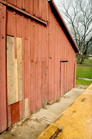 A portion of the south side of the Maplewood Barn theater in Nifong Park is boarded up after it was broken into and vandalized this week. Vandals apparently entered the barn by pulling boards off the side and climbing through.