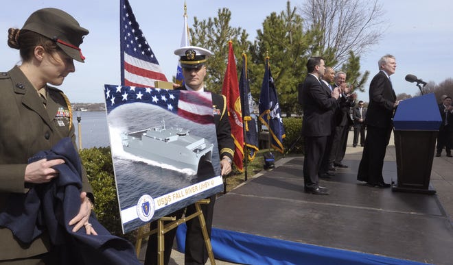 U.S. Marine Corps Capt. M Alexis Wright and U. S. Navy LCDR Sean Bartlett unveil an artist's rendering of the USNS Fall River, just as U.S. Secretary of the Navy Ray Mabus makes the big announcement.