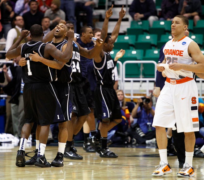 As Butler celebrates, Syracuse's Brandon Triche, right, leaves the floor at the end of an NCAA West Regional semifinal college basketball game in Salt Lake City, Thursday, March 25, 2010. Butler won 63-59. (AP Photo/Colin E. Braley)
