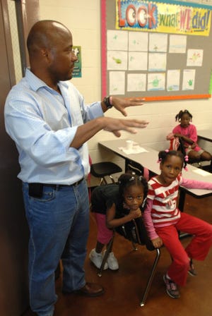 MaliVai Washington (left) looks in one of the first grade class rooms at the youth center during a tour of the facilities at the MalVai Washintgon Kids Foundation. The former tennis professional is being named the ATP Tour's 2009 Arthur Ashe Humanitarian of the Year.