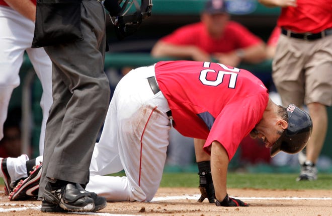 Boston's Mike Lowell goes down after hitting himself on his left knee with a fouled-off pitch in the first inning of Friday's spring training game.