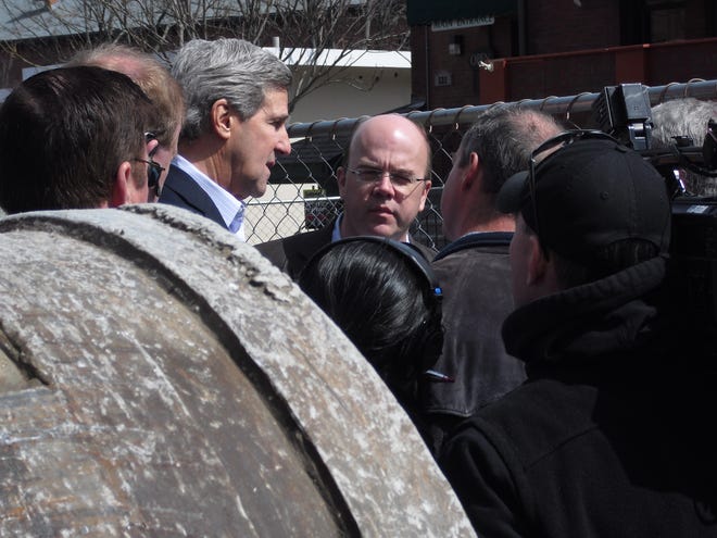 U.S. Sen. John Kerry and U.S. Congressman James McGovern look at the sinkhole on Main Street during a tour of flood damaged buildings.