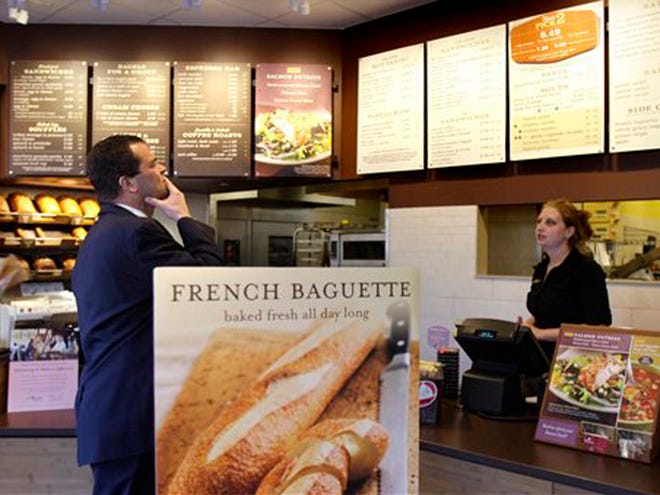 In this March 8, 2010 file photo, a customer reviews the sandwich board at the Panera store in Brookline, Mass. Panera bread company is announcing that they will become the first chain to post calories on menus nationally.