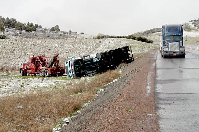 Above, a tow truck prepares to lift a Gordon Trucking semi truck that was driven by Shayne Cleaveland of Central Point, Ore., off the side of a small hill on the right shoulder of northbound Interstate 5 about three miles north of Yreka (just past the dragon sculpture). Cleaveland had parked the truck, which was carrying about 30,000 pounds of Kellogg’s cereal, in the chain-up area and stepped back into the sleeping quarters when he felt it begin to tip over just before noon on Monday. He was not hurt, but he was cited for not setting a parking brake on an unattended vehicle.