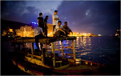 Fishermen return to their neighborhood where more than 1,000 residents live in cramped alleyways across the water from luxury developments in Sanya, China.