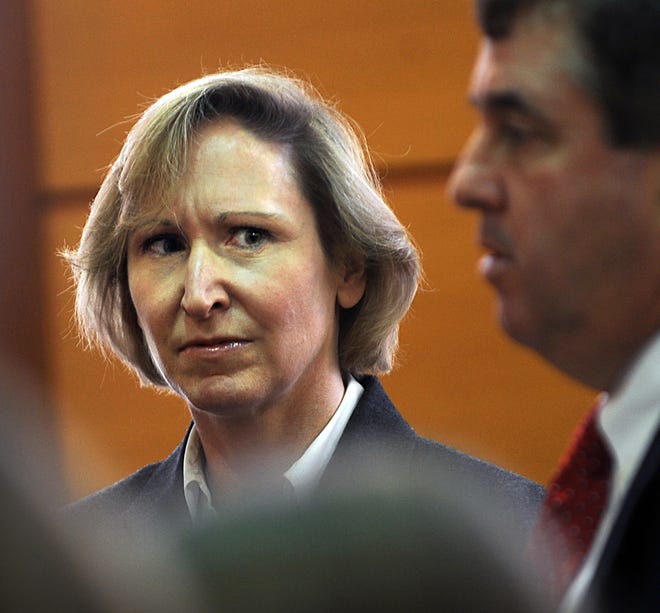 Martha Fulham of Natick listens to her attorney, Peter Muse, yesterday during her appearance in Framingham District Court.