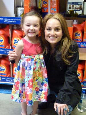 Angelina Townsend, 5, of Derry, N.H., poses with Giada De Laurentiis at BJ's in Franklin on Friday where she was doing a book-signing.