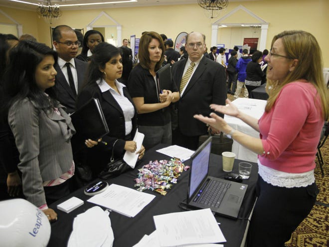 Rachel Leathers, right, of Leapfish describes a sales professional job to a group of job
seekers at a career fair put on by National CareerFairs in San Jose,
Calif., on Tuesday. Initial claims for unemployment benefits fell slightly last
week as the recovering economy moves closer to generating more
hiring.
