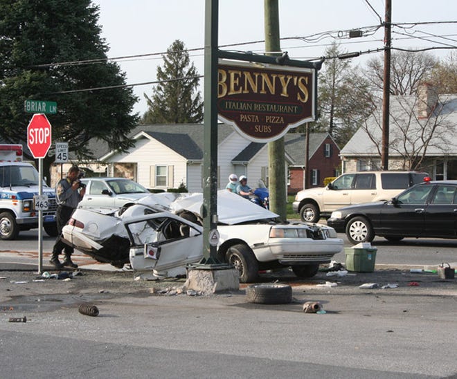 A Pennsylvania State Police trooper takes photos after the fiery, high-speed accident at the intersection of U.S. 30 and Briar Lane in Chambersburg Friday afternoon that seriously injured three people, including two children.