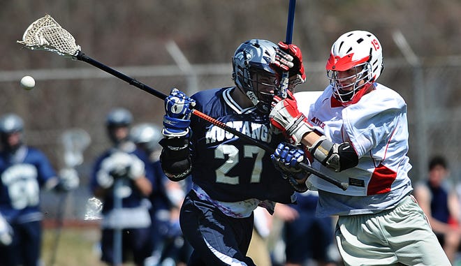 Natick's Craig Christie knocks the ball from Medway's Johnny Jacoby on Saturday.