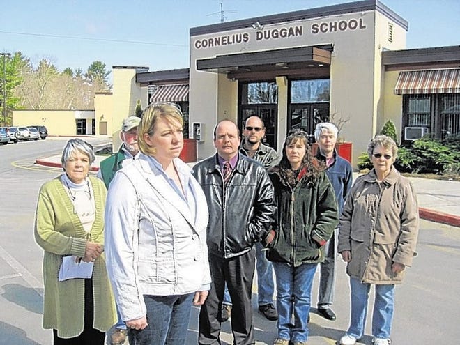 Jo-Ann Peabody, in white, a Monticello school board member; Bethel Supervisor Daniel Sturm, wearing tie; and concerned parents and residents gather on March 24 to discuss the board's decision to close the Cornelius Duggan School.