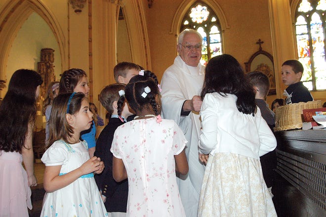 Father William Kelley quizzed a group of children with a game of "detective" during Sunday's Easter Mass at Taunton's St. Mary's Church.