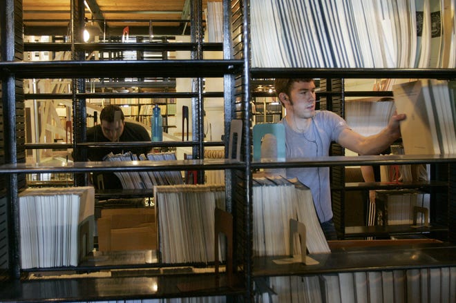 Michael Ramirez, left, and Logan Lambrecht, right, pull books from the shelves of the State Library of Kansas on Wednesday. VonRentzell Movers is moving the books to a warehouse until renovations on the Statehouse are complete in 2012.