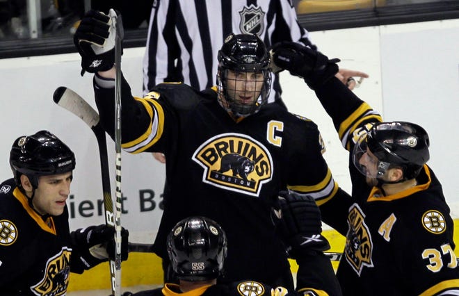 Boston Bruins defenseman Zdeno Chara, center, is congratulated by teammate after his goal against the Buffalo Sabres in the third period on Thursday night.
