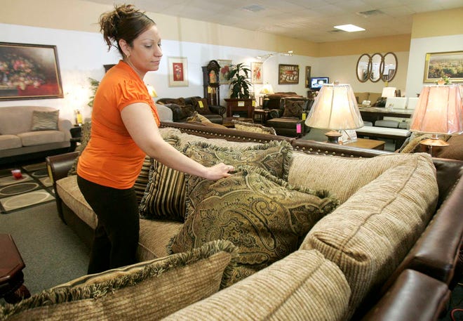 Vaughn's Home Furnishings sales member Rocio Puebla straightens pillows on a furniture display at the Auburn Street on Friday, April 9, 2010.