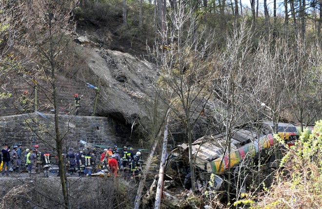 Firefighters search the wreckage of a train derailed near Merano, northern Italy, Monday, April 12, 2010, after a landslide hit and derailed the train in northern Italy on Monday, killing 11 people and leaving some 30 injured, officials said. Rescuers were working to pull out the bodies of victims and find possible survivors.
