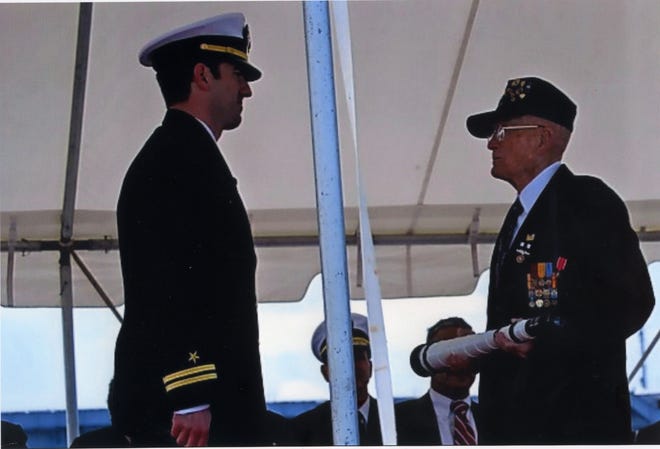 Hugh Smith is passing the long glass to the officer of a new ship at its commissioning, a Navy tradition.