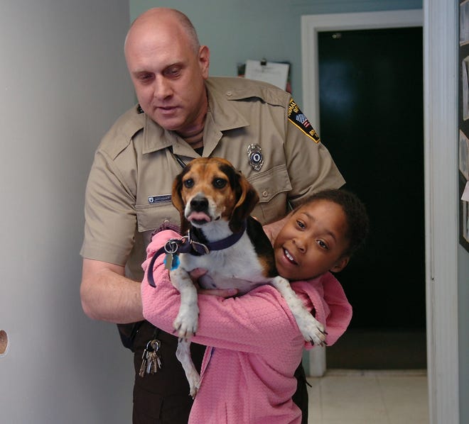 Taylor Cameron, 8, is reunited with her lost beagle, Buddy, by Brockton Animal Control Officer John Kostka on Monday. Kostka calls it the best job he has ever had. Taylor would agree.