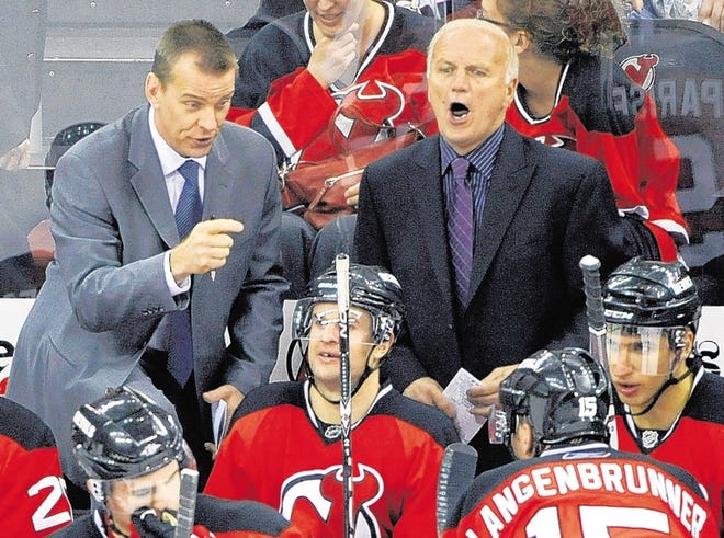New Jersey Devils assistant coach Tommy Albelin, left, and head coach Jacques Lemaire talk to their players during the third period of an NHL hockey game against the Buffalo Sabres Sunday, April 11, 2010 in Newark, N.J. The Devils won 2-1. (AP Photo/Bill Kostroun)